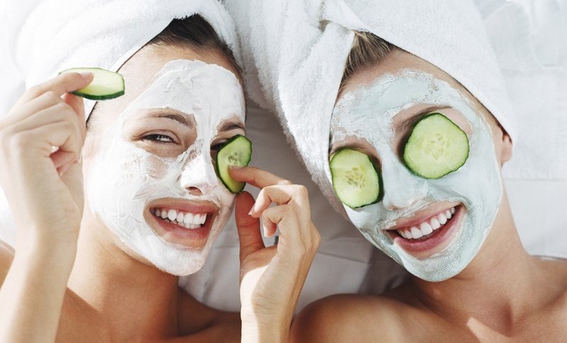 Two girls with cleansing masks on their faces.