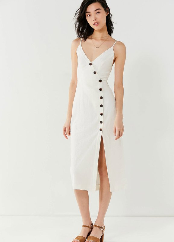 Asymmetric button arrangement on a white dress Asymmetric button arrangement on a white dress