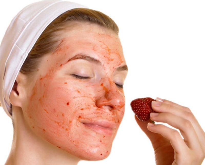 Strawberry Juice Mask Girl rubs her face with strawberry juice