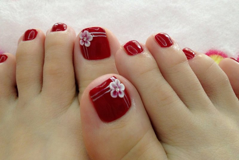 Red gel polish with modeling Pedicure red with a flower (modeling)