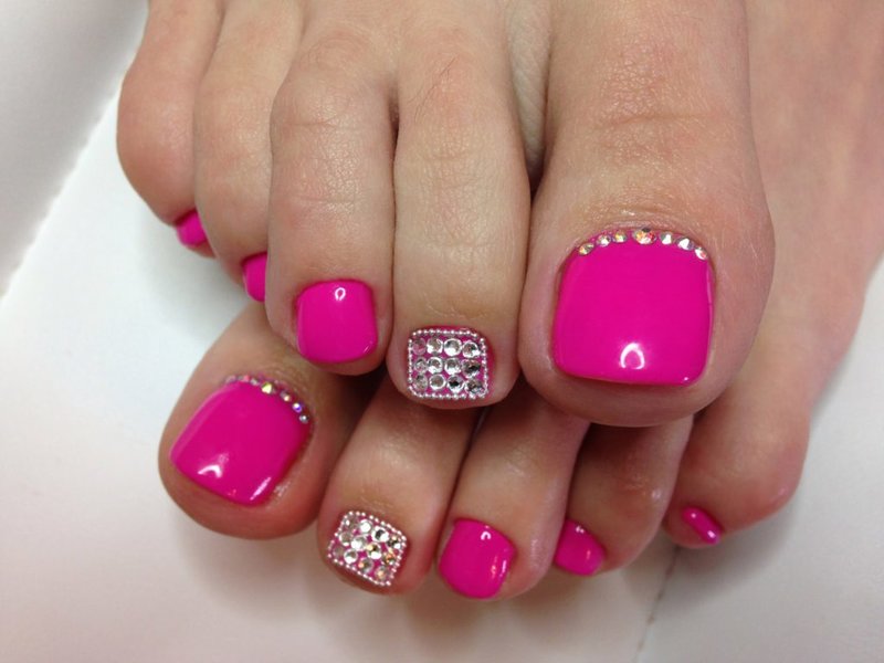Intense pink pedicure Pink gel polish with rhinestones