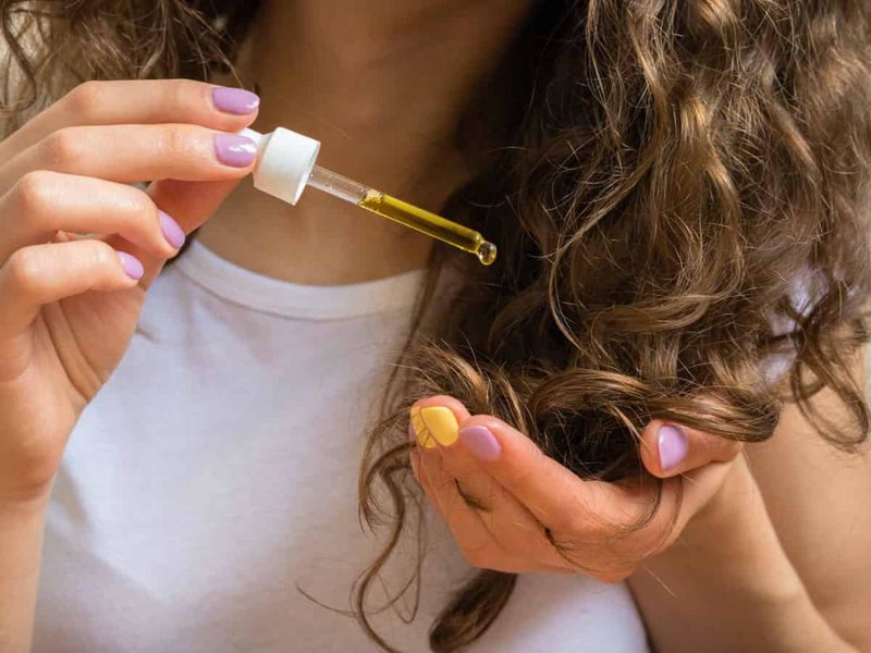 Girl uses jojoba oil at the ends of her hair