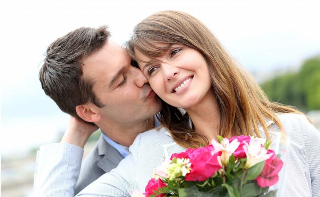 A man kisses a woman