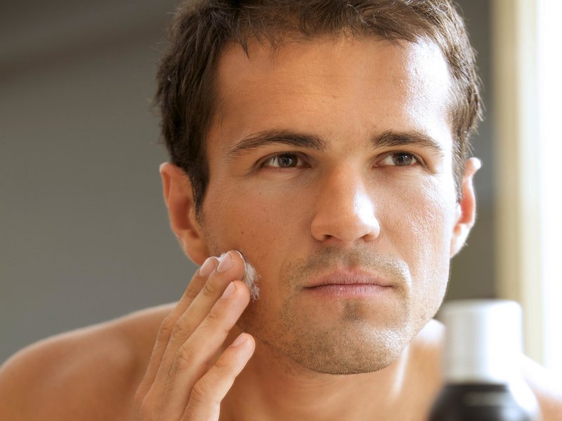 A man applies cream on his cheeks Men's face cream