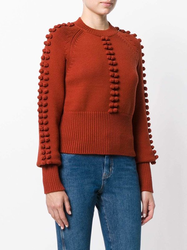 Girl in a sweater with textured pompons