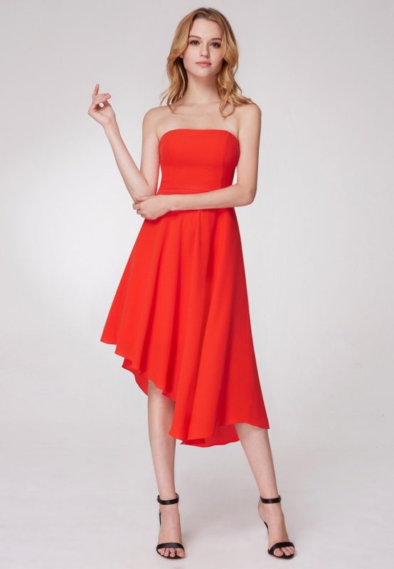 Girl in an orange cocktail dress with bare shoulders and an asymmetrical hem Girl in an orange cocktail dress with bare shoulders and an asymmetrical hem