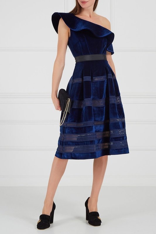 Girl in a dark blue velvet cocktail dress with one open shoulder Girl in a dark blue velvet cocktail dress with one open shoulder