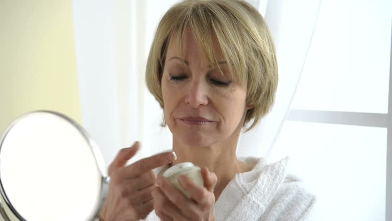 Woman after 50 moisturizes her face Woman after 50 moisturizes her face