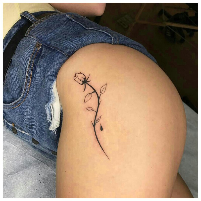 Tattoo on the hip of a girl in the form of a delicate flower